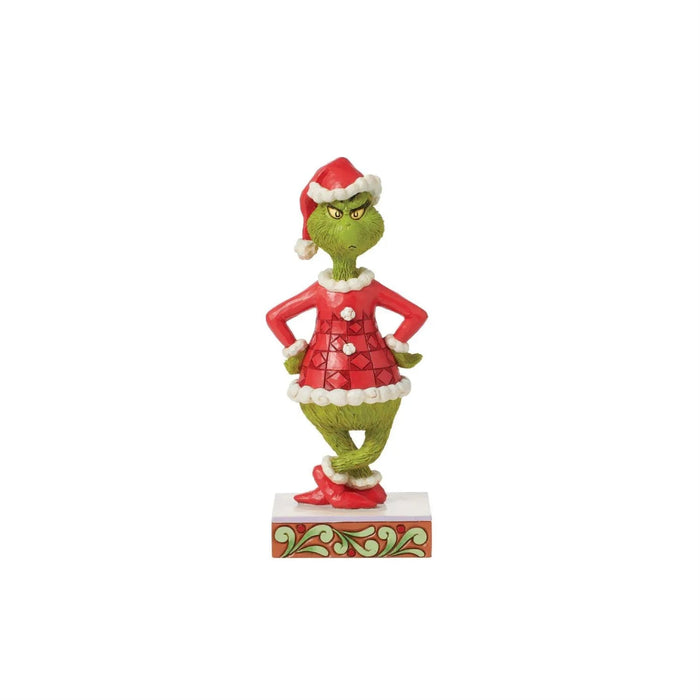 "Front view of Jim Shore Grinch figurine in red patchwork Santa suit, standing on stage with hands on hips and frowning."