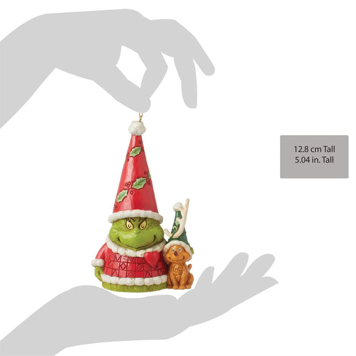 Jim Shore Grinch Gnome Christmas ornament  in a red hat with Max the  dog, held by a hand with measurements  against a white background.
