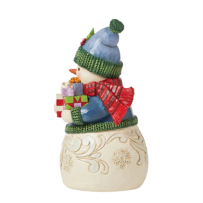 Right side view of Jim Shore Decorative snowman figurine with a blue coat, green hat, and holding presents  on a white background.