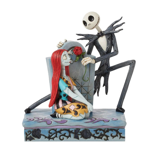 Collectible figurine of Jack Skellington and Sally standing by a decorative gravestone, designed by Jim Shore, on a white background. 

