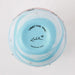 Decorative glass bowl with blue interior and multicolored exterior on a white background