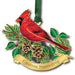 Christmas ornament with a red cardinal, green leaves, and pine cones on a white background.