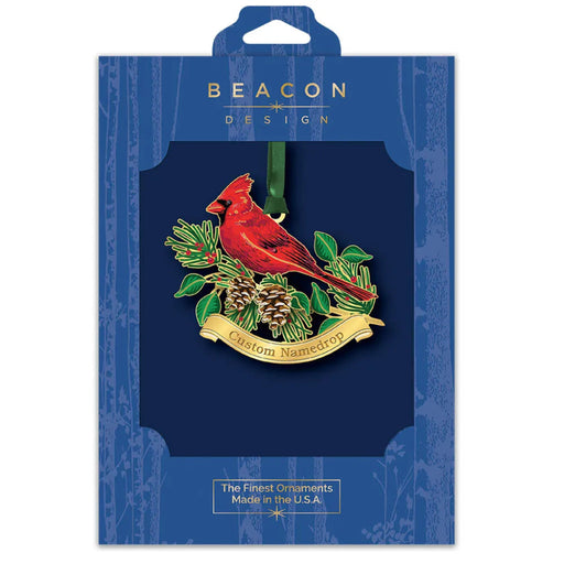 Beacon Design Christmas ornament packaging with a red cardinal and greenery design.