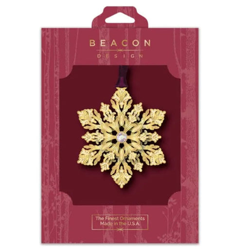 Gold snowflake ornament in Beacon Design packaging on a white background