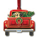 Decorative Christmas ornament of a red truck with two dogs and a wreath, featuring a USA license plate.
