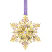 Decorative snowflake ornament with gold detailing and a purple ribbon on a white background