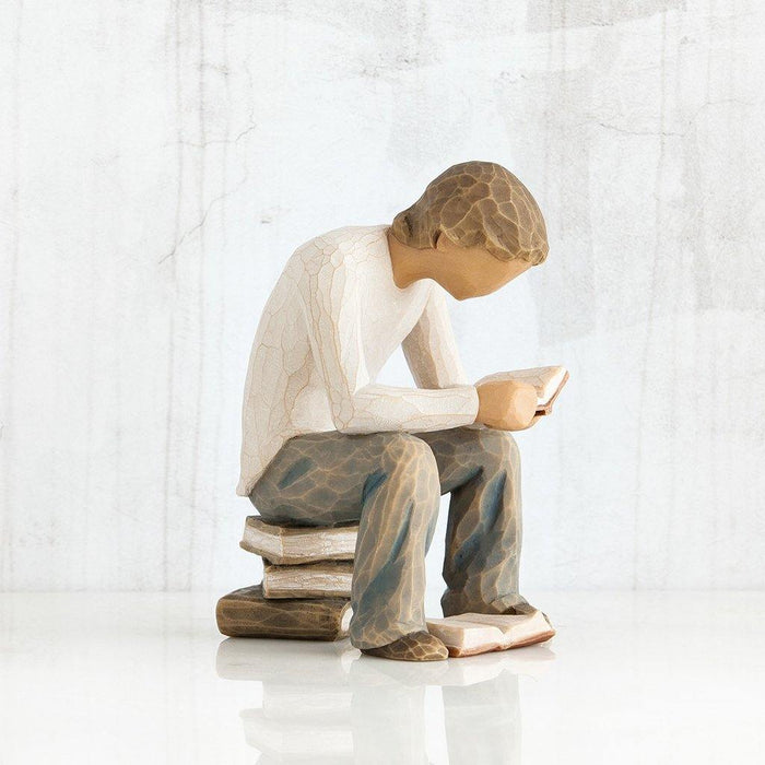 "Willow Tree Quest Figurine of boy reading book on stack of books – hand-carved resin sculpture by Susan Lordi, symbolizing learning and discovery"