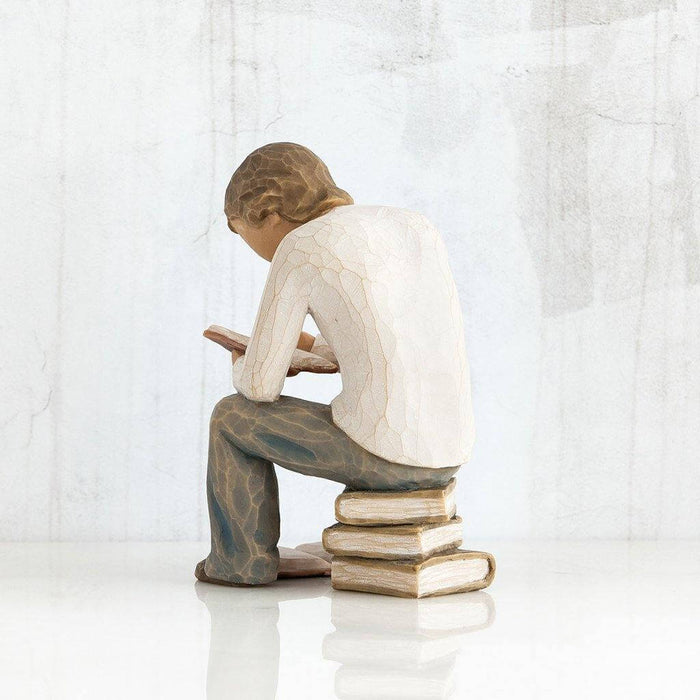 "Willow Tree Quest Figurine of boy reading book on stack of books – hand-carved resin sculpture by Susan Lordi, symbolizing learning and discovery"