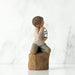 "Willow Tree Love You Too figurine – hand-painted sculpture of a boy with lighter skin kneeling and holding a wire sign that says 'love you'."