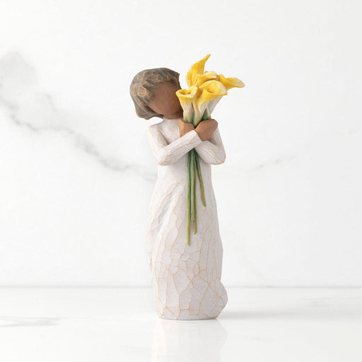 "Willow Tree With Gratitude figurine – hand-painted resin sculpture of a woman with darker skin tone holding a bouquet of yellow calla lilies in appreciation."
