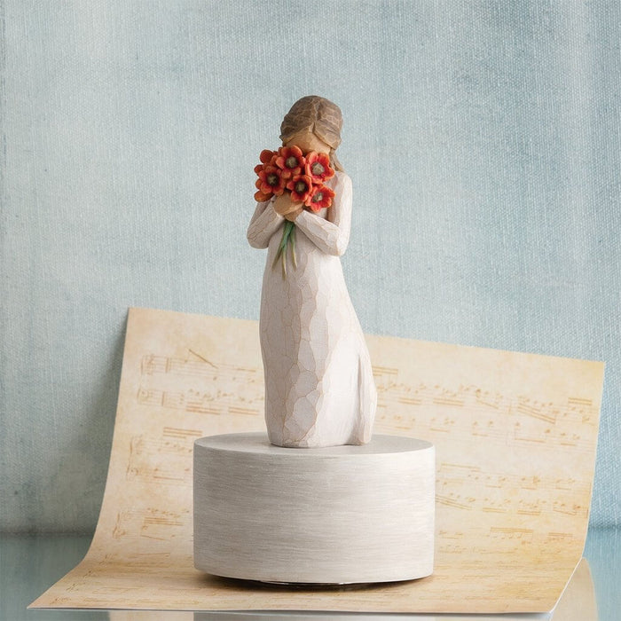 "Willow Tree Surrounded by Love musical figurine – resin sculpture of woman holding red poppies, set on rotating base that plays 'Let Me Call You Sweetheart'."