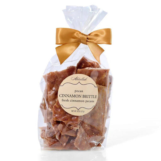 "Bag of pecan cinnamon brittle with a gold bow on a white background"