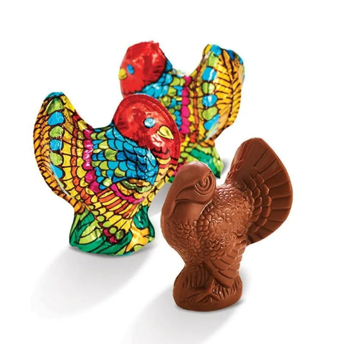 "Colorful ceramic rooster figurine and brown rubber chicken toy on a white background"