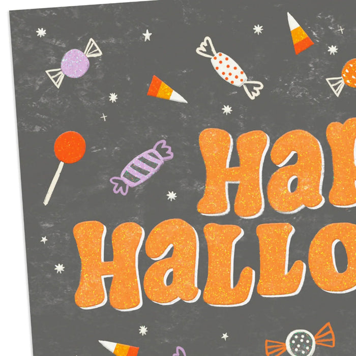 Close-up of Hallmark Halloween card with colorful candy artwork and sparkling glitter details