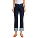 A model wearing dark navy blue cropped jeans with rolled cuffs, paired with a white top and brown flat shoes, shown against a plain white background.