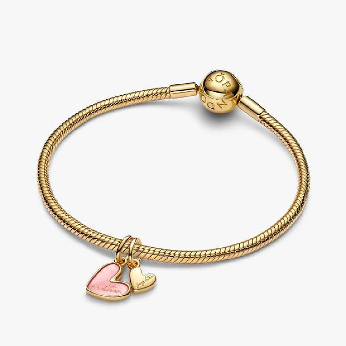 A heart charm embellished with bright pink enamel, highlighting its delicate and attractive design.