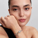 Disney’s Tiana Water Lily charm with lab‑grown diamond worn on a bracelet alongside other charms on the wrist
