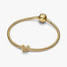 Golden butterfly-shaped charm on a light background