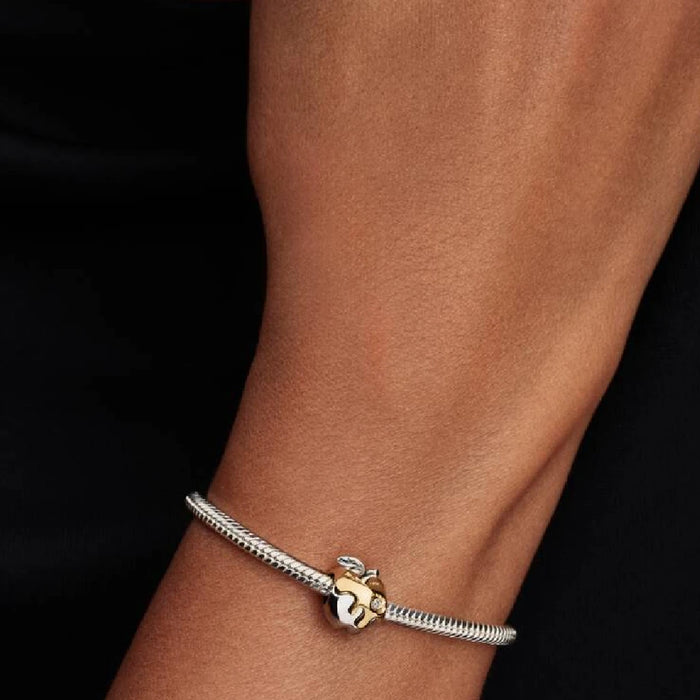 A Pandora charm with a stylized apple, representing themes of temptation and the quest for wisdom.