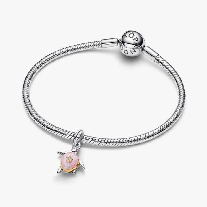 Silver bracelet with a pink charm on a white background
