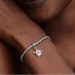 Close-up of a person's wrist wearing a bracelet with a turtle charm.