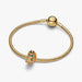 A gold dog charm with a distinctive blue and white face, representing a cute and stylish accessory.