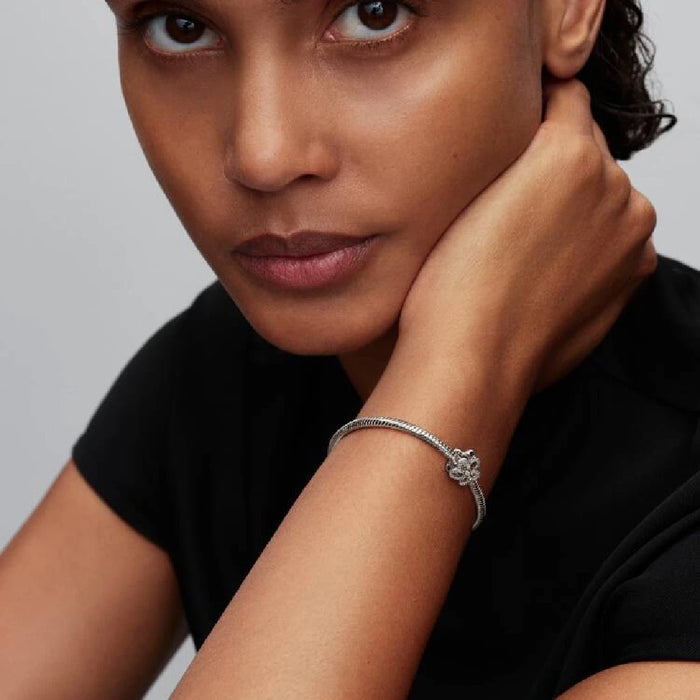 A diamond flower charm against a white backdrop, accentuating its beauty and intricate details.