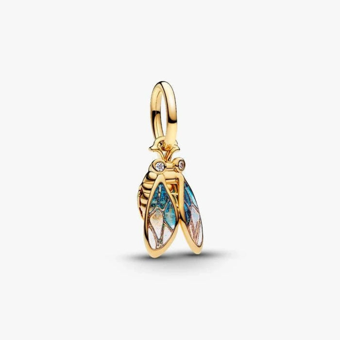Gold cicada-shaped charm on a light background
