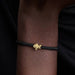 Bracelet with a gold clasp on a wrist against a dark background