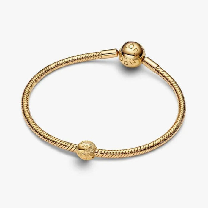 Gold bracelet with two charms on a white background