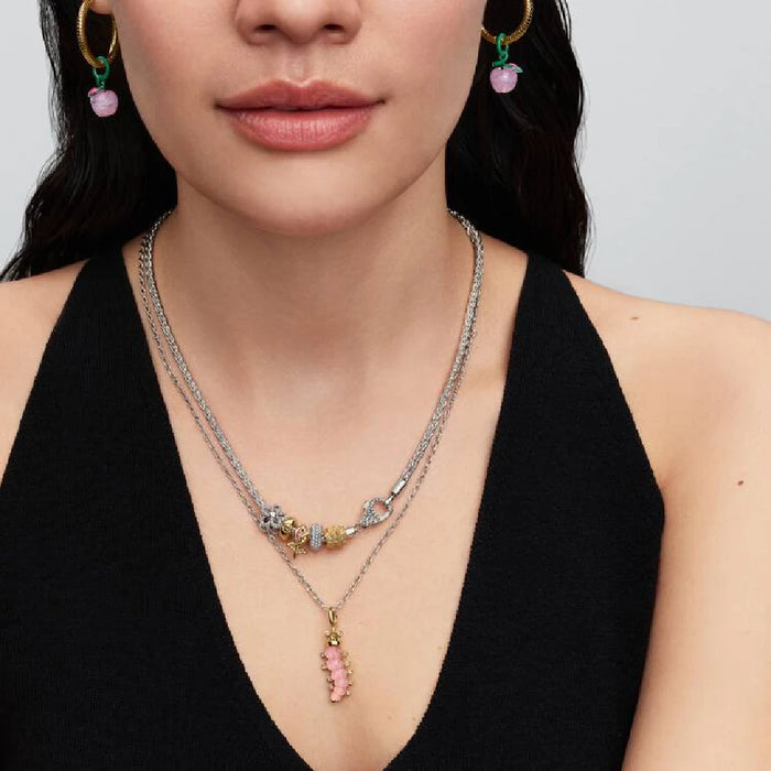 Gold plated rose charm with pink stones, representing a blend of luxury and floral beauty in jewelry design.
