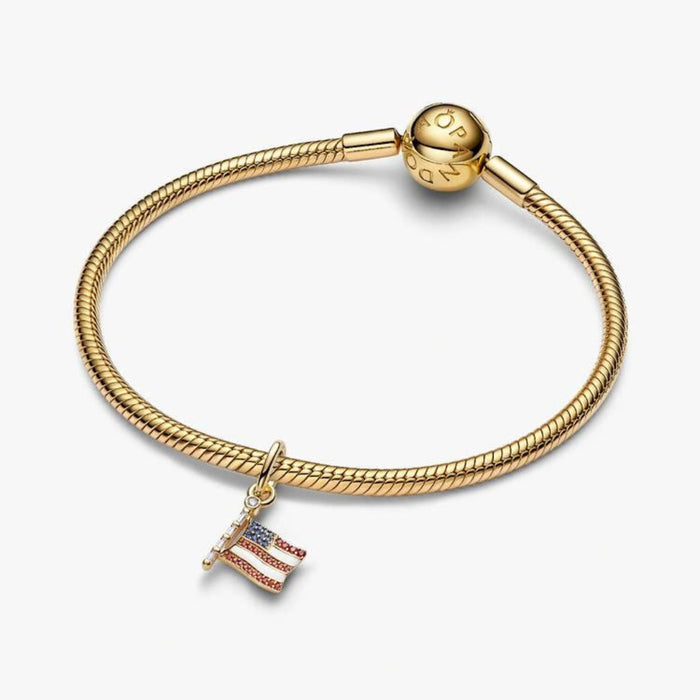 Gold-tone American flag dangle charm adorned with red, white, and blue crystal accents, designed for charm bracelets