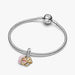 A Pandora charm in the shape of a heart, embellished with a vibrant pink stone for a chic look.