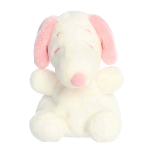  A white stuffed animal with pink ears, sitting upright against a soft background.