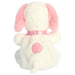 A white plush animal with pink ears, placed on a simple, light-colored surface.