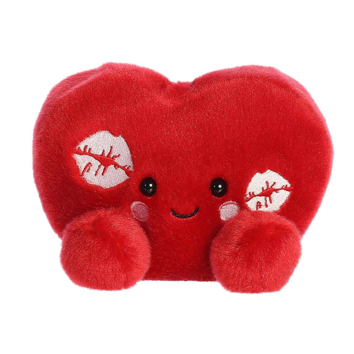A red heart-shaped pillow adorned with various lipstick kisses, symbolizing love and affection.