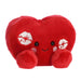 A vibrant red heart pillow featuring playful lipstick kiss marks, representing romance and tenderness.