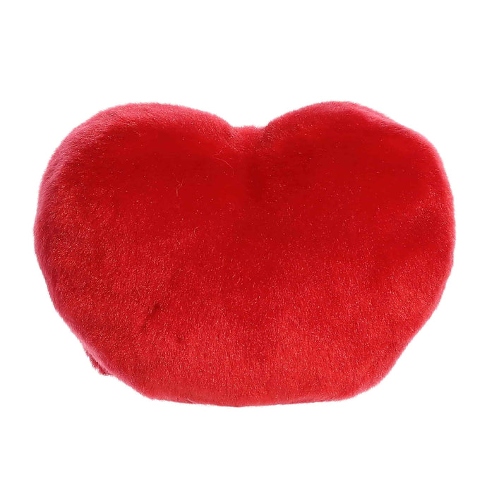 A red heart pillow with printed kisses, illustrating a romantic theme and a cozy atmosphere.