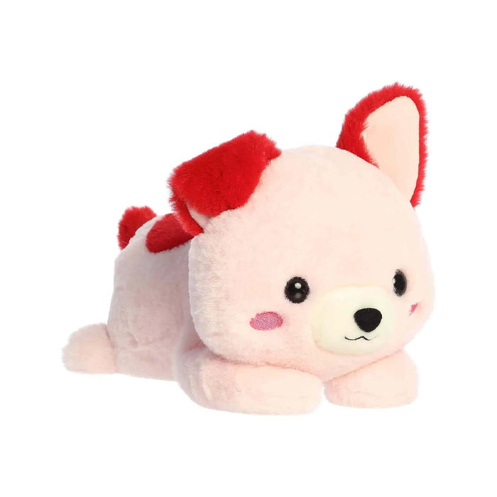 A plush pink toy with a bright red collar, positioned on a soft surface.