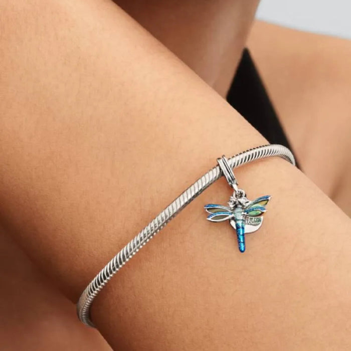PANDORA Dragonfly Double Dangle Charm in sterling silver with transparent and holographic glitter enamel wings, sparkling stone eyes, and a “Free Spirit” engraved disc for PANDORA Moments bracelets.
