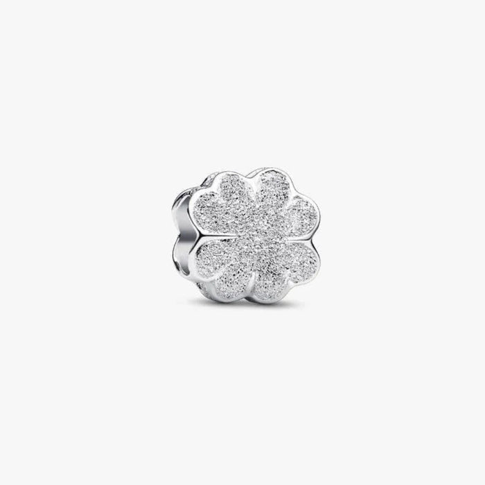 Silver four-leaf clover charm on a white background