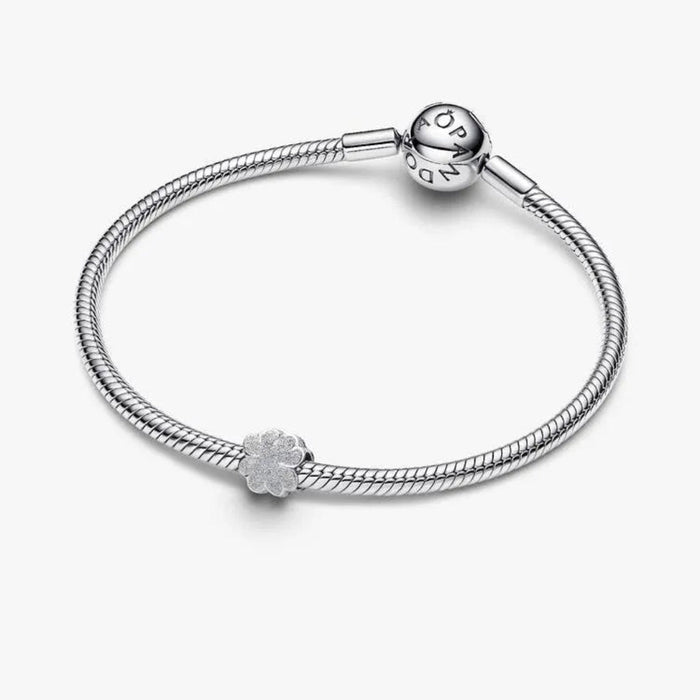 Silver bracelet with a textured charm on a white background