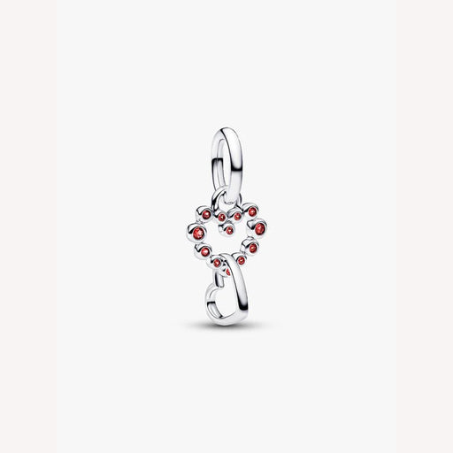 Silver heart with red gemstones on a light background