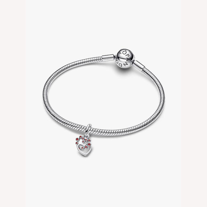 Silver bracelet with a heart-shaped charm on a light background