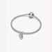 Silver bracelet with a heart-shaped charm on a light background