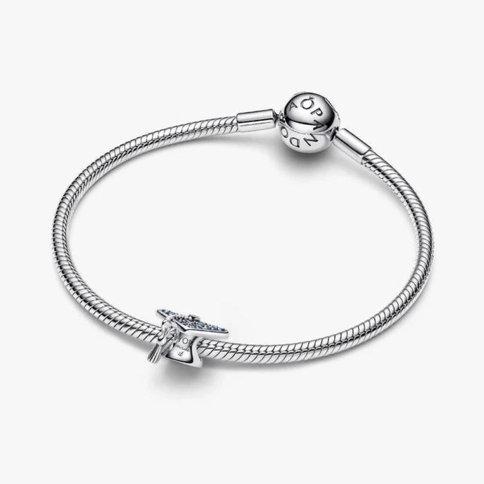 Silver graduation cap charm on a light background