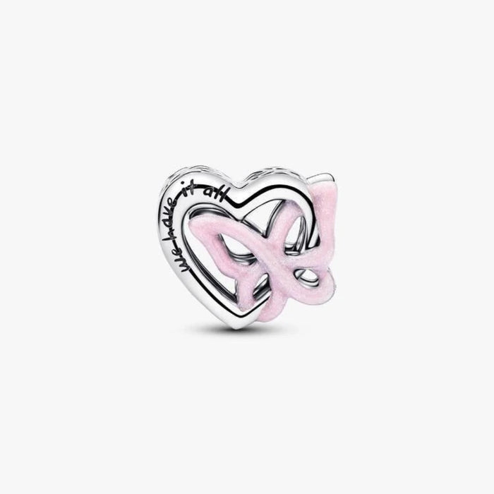 Silver heart and butterfly shaped charm on a light background