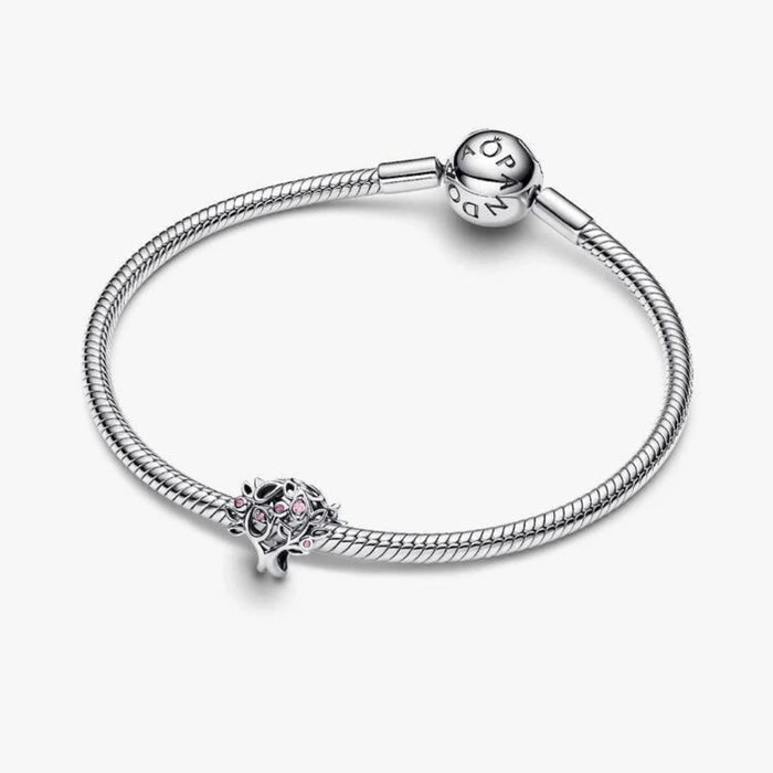 Silver tree-shaped charm on a light background