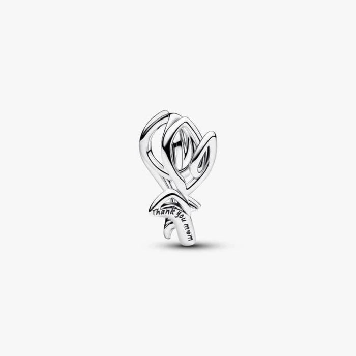 Silver tulip shaped charm on a light background