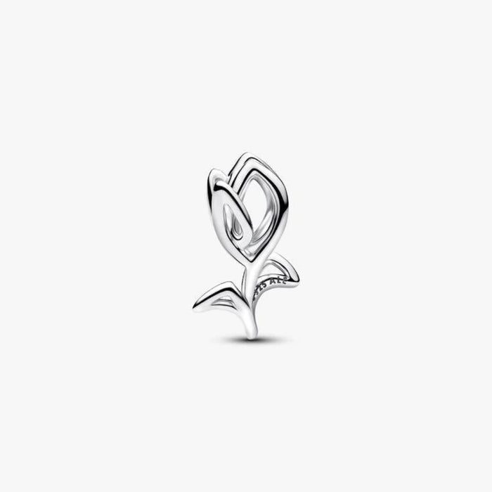 Silver tulip shaped charm on a light background